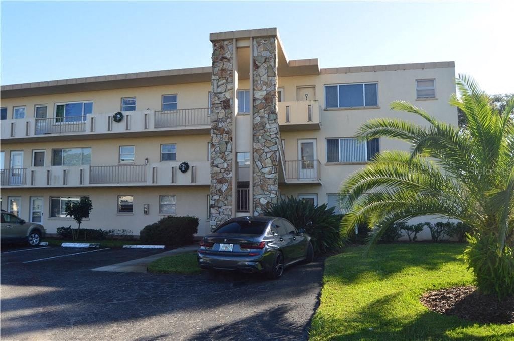 an apartment building with a car parked in front of it