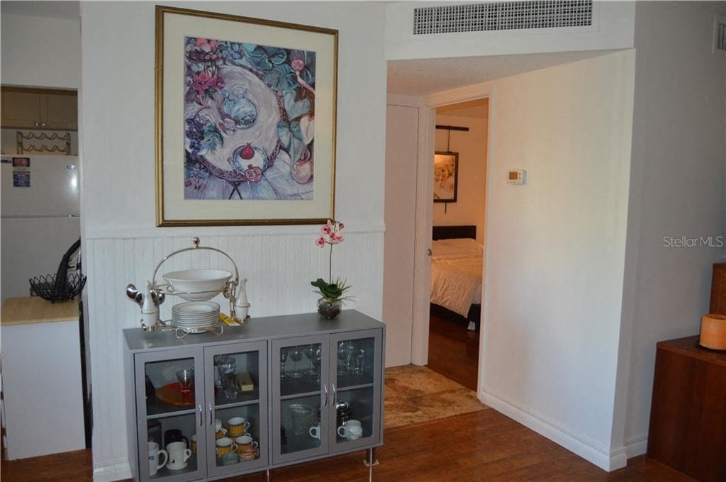 a living room with a cabinet and a painting on the wall