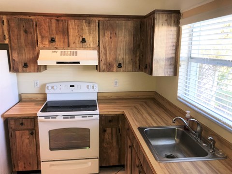 a kitchen with wooden cabinets and a stove and sink
