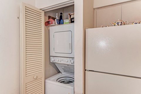 a washer and dryer in a kitchen next to a refrigerator