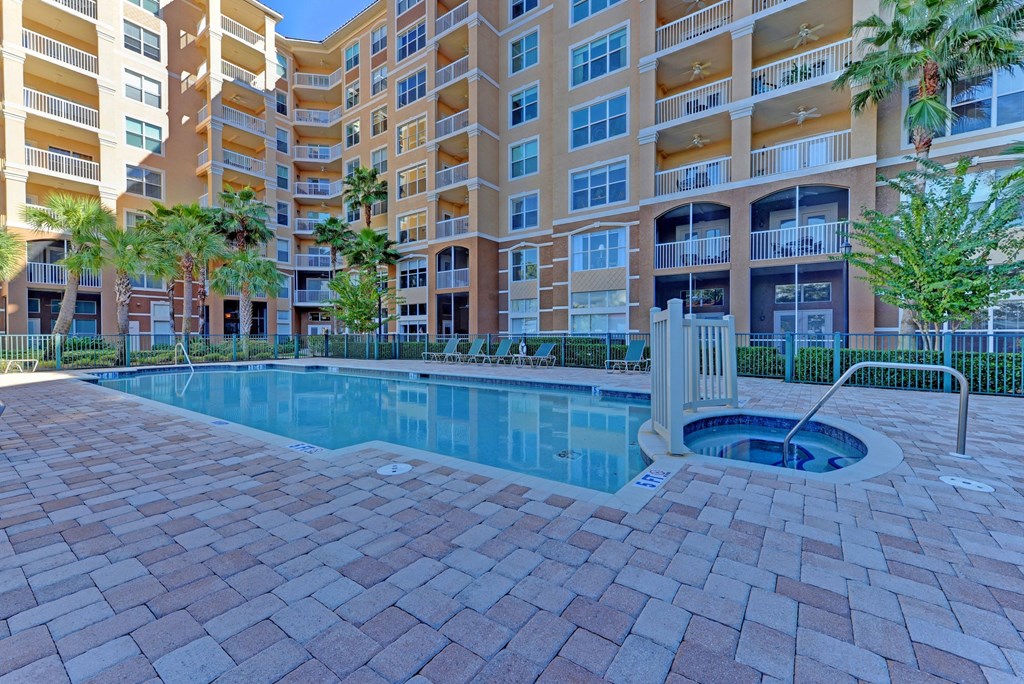 a swimming pool with an apartment building in the background