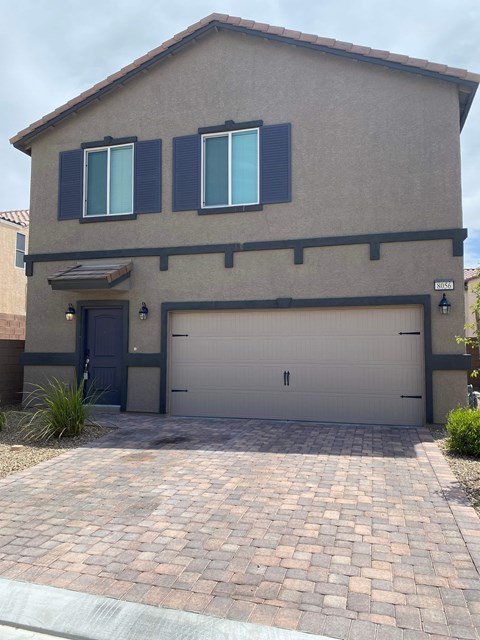 A house with a grey garage door and a black door.