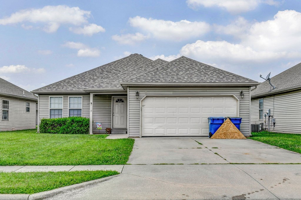 a white house with a garage door and a driveway
