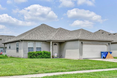 a gray house with a lawn in front of it