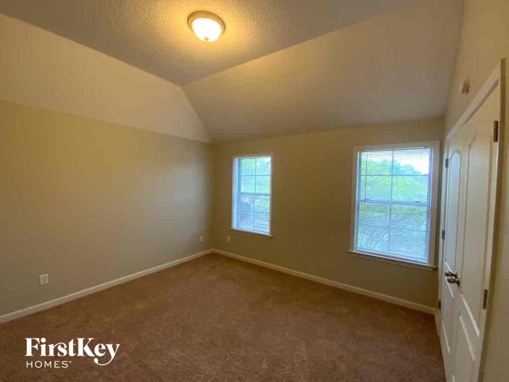 an empty bedroom with a door and a window