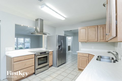 A kitchen with wooden cabinets and a stainless steel refrigerator.