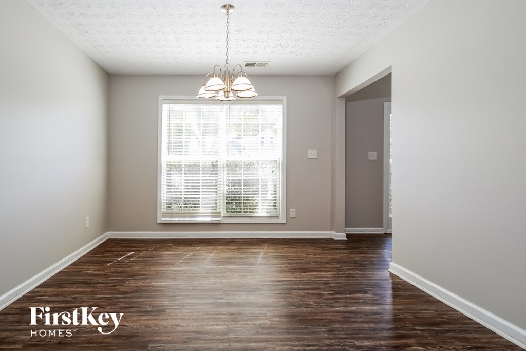 a living room with a large window and wooden floors