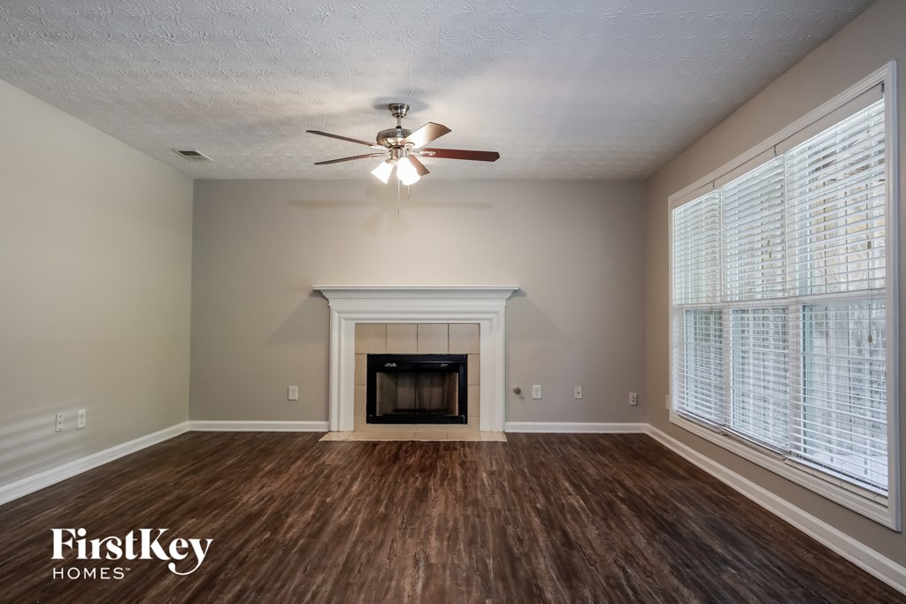 a living room with a fireplace and a ceiling fan