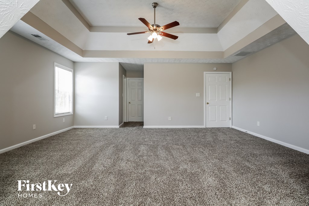an empty living room with a ceiling fan