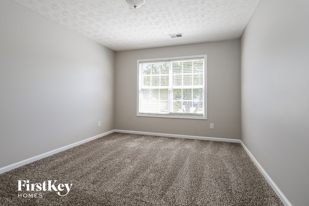 a empty room with carpet and a window