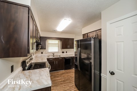 a kitchen with black appliances and white marble counter tops