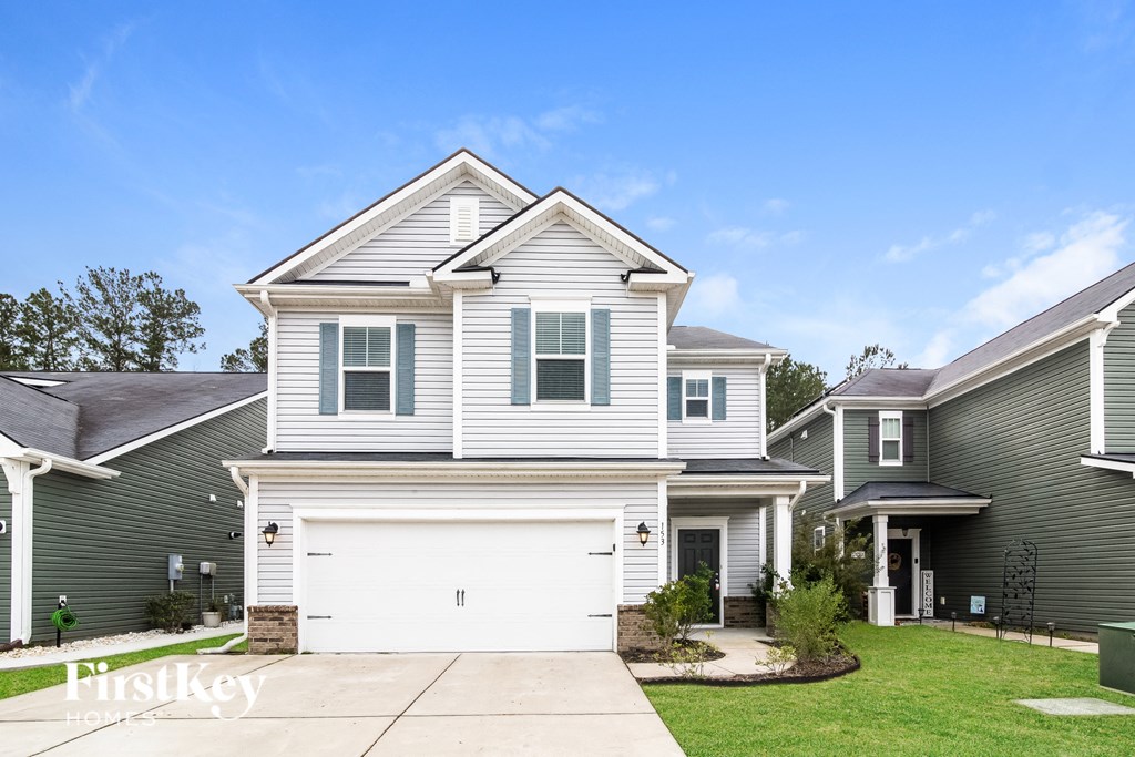 a white and gray house with a white garage door