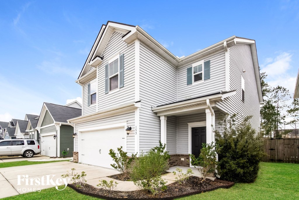 a white house with white vinyl siding and a white car garage