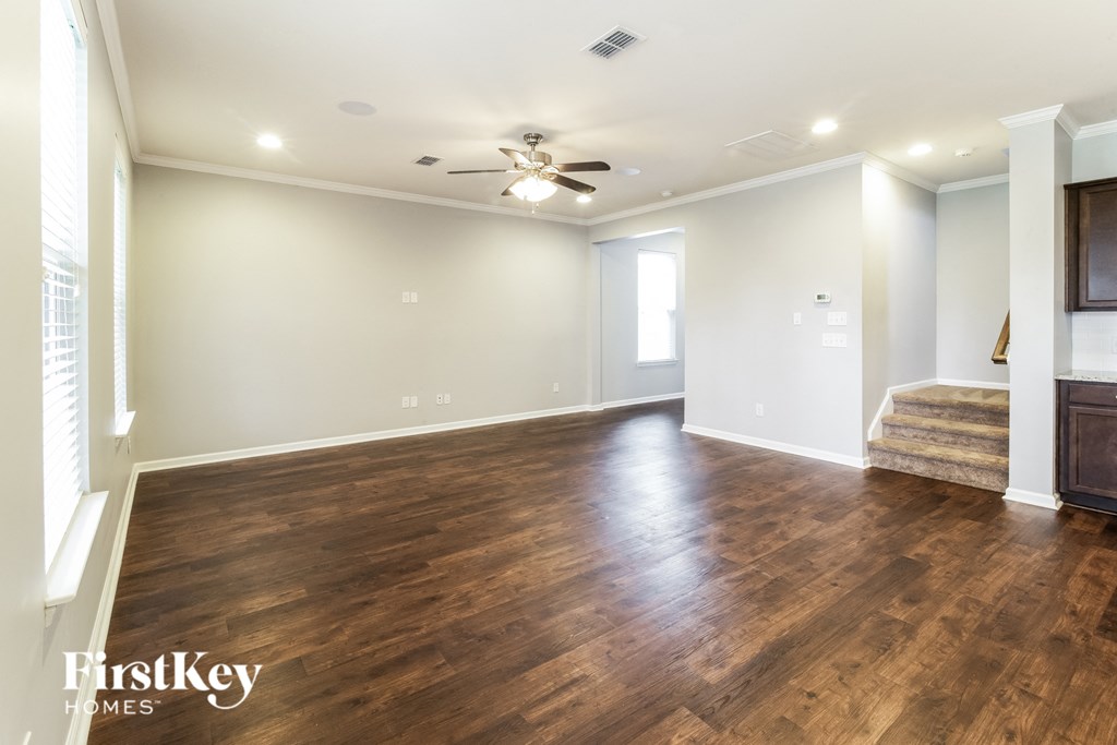 a living room with wood floors and a ceiling fan