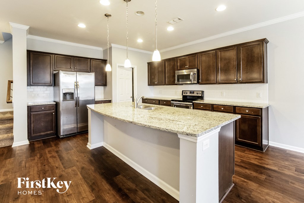 a kitchen with a large island and stainless steel appliances
