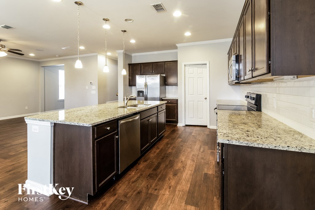 a kitchen with granite counter tops and dark wood cabinets