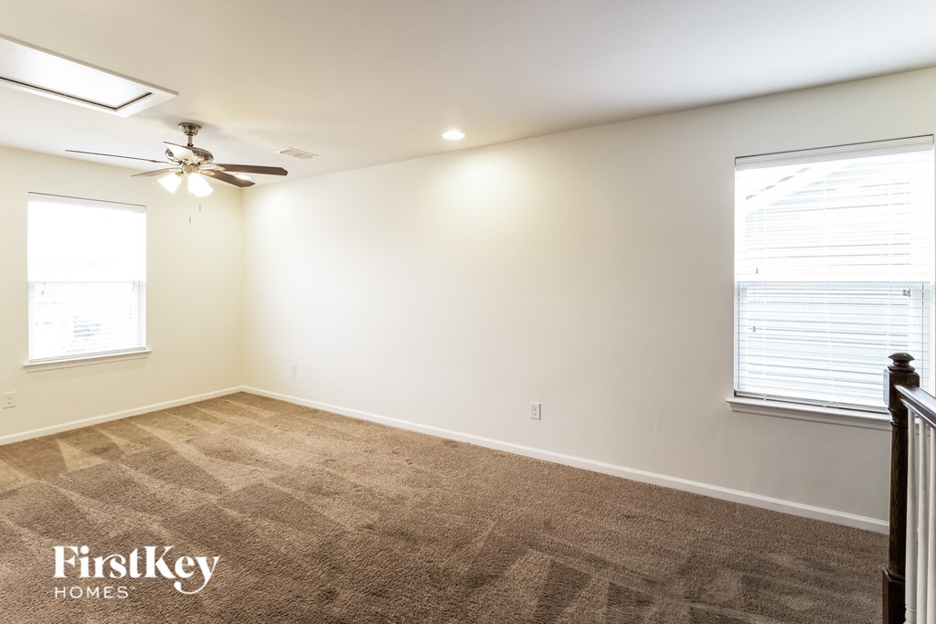 a bedroom with a carpeted floor and a ceiling fan