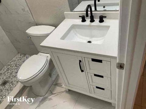 a bathroom with a white sink and a toilet