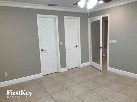 a living room with three doors and a tiled floor