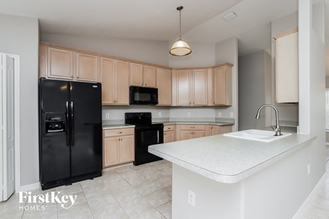 a large kitchen with black appliances and white counter tops