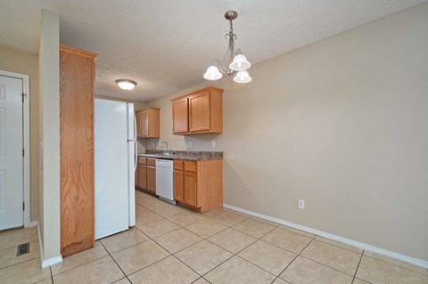 A kitchen with wooden cabinets and a white refrigerator.