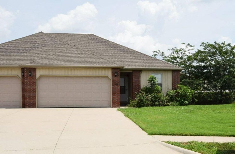 A house with a brown roof and two garage doors.