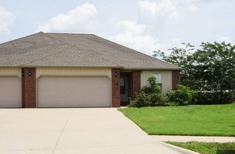 A house with a brown roof and two garage doors.