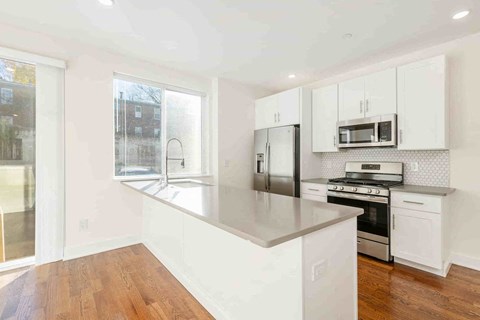 a kitchen with an island and a stove and a window