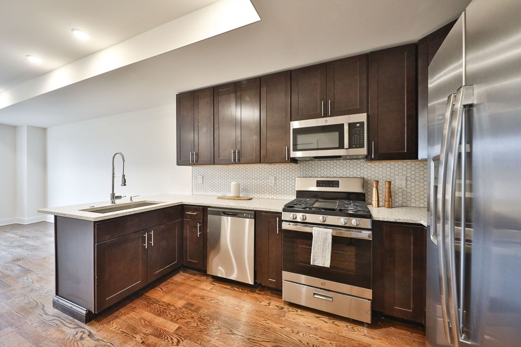 a kitchen with dark wood cabinets and stainless steel appliances