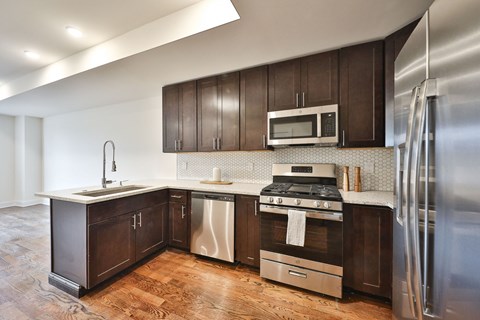a kitchen with dark wood cabinets and stainless steel appliances