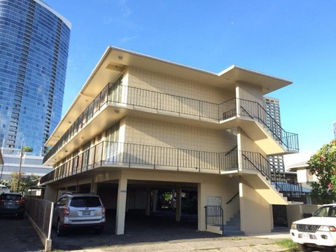 A modern two-story building with a balcony on the second floor.