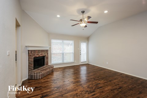 a living room with a fireplace and a ceiling fan