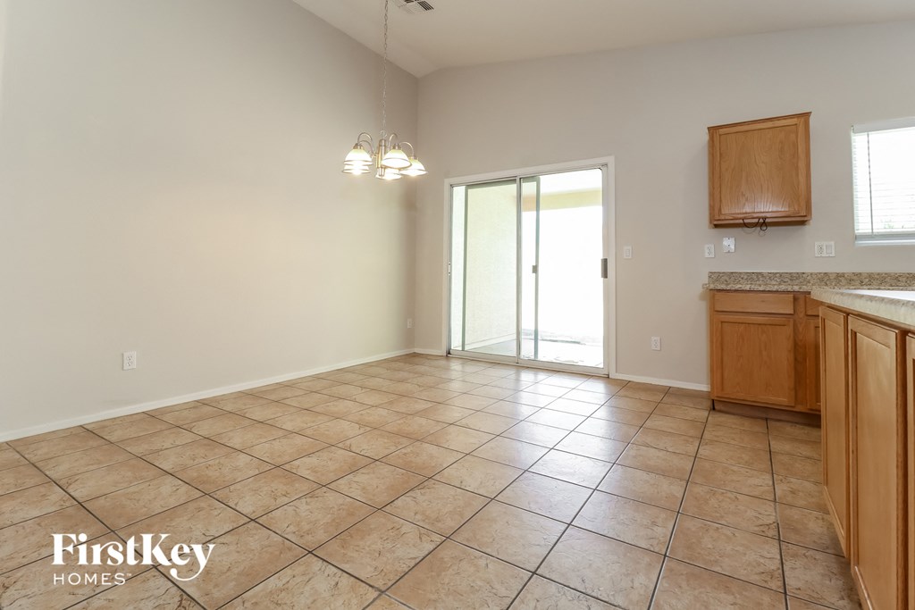 A spacious kitchen and living room with tile flooring and wooden cabinets.