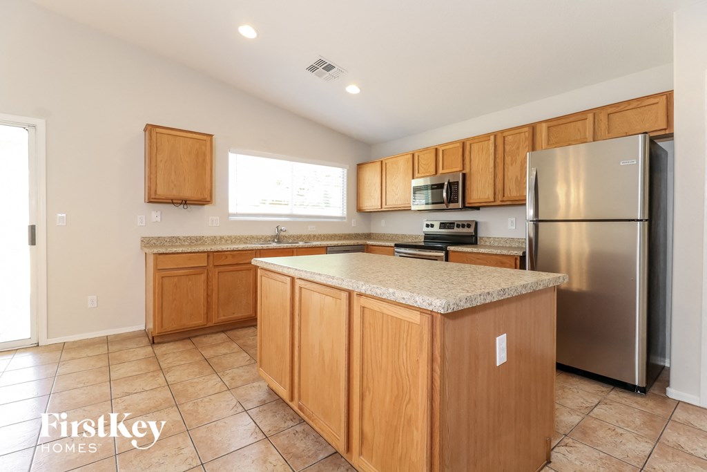 A kitchen with wooden cabinets and a granite countertop.