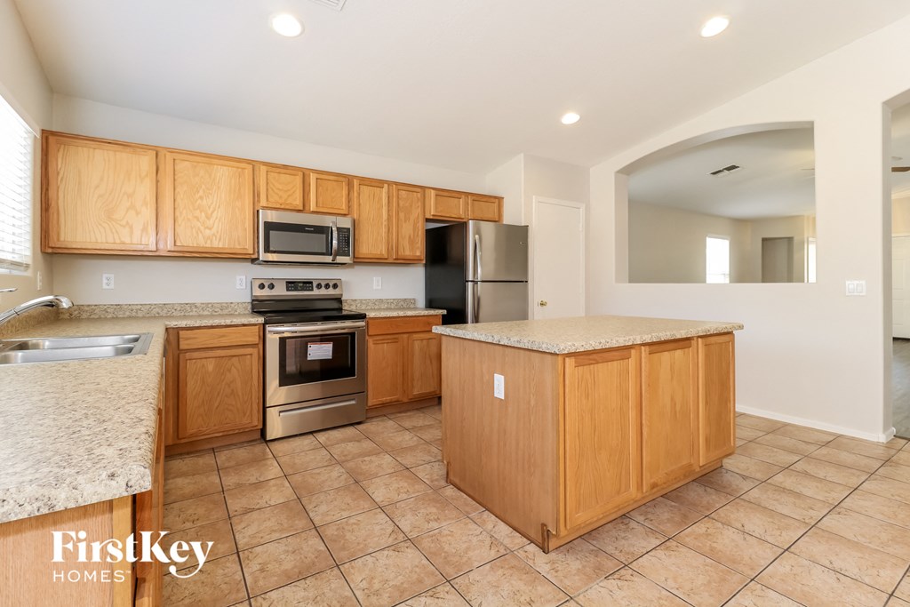 A kitchen with wooden cabinets and a granite countertop.