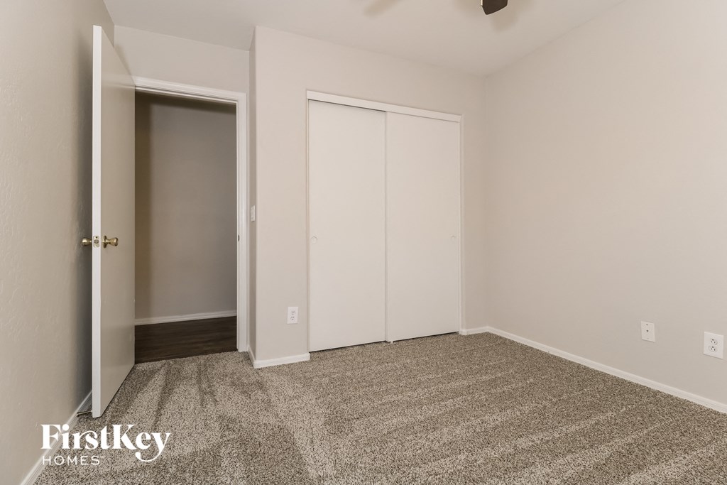 A room with a carpeted floor and two white doors.