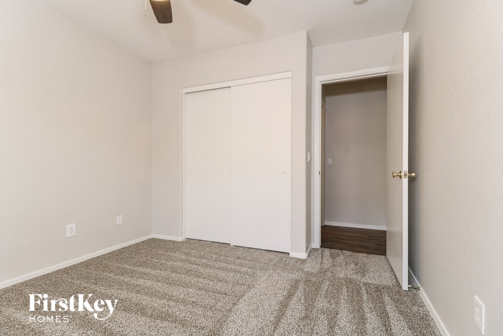 A room with a carpeted floor and a doorway leading to another room.