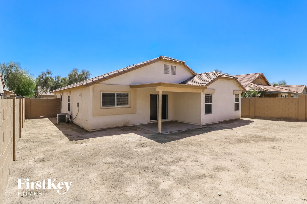 A small house with a brown roof and a brown fence.