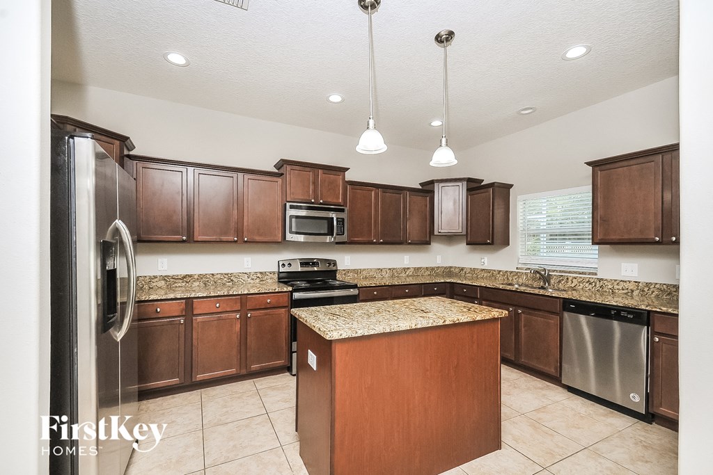 a kitchen with wooden cabinets and granite counter tops and stainless steel appliances