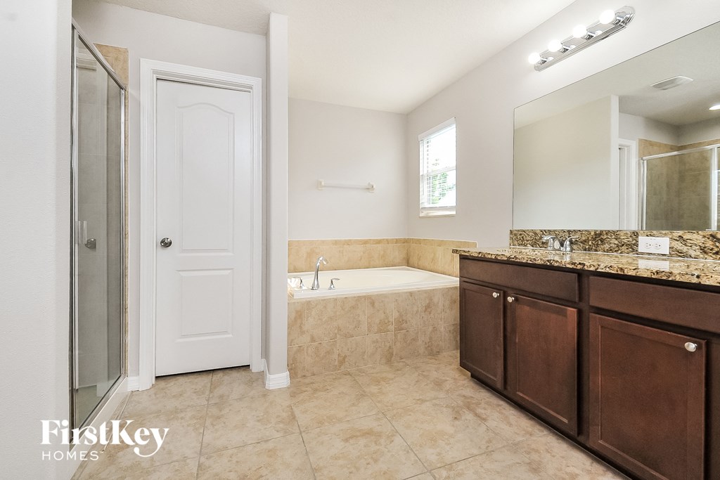 a bathroom with a bath tub and a sink and a mirror
