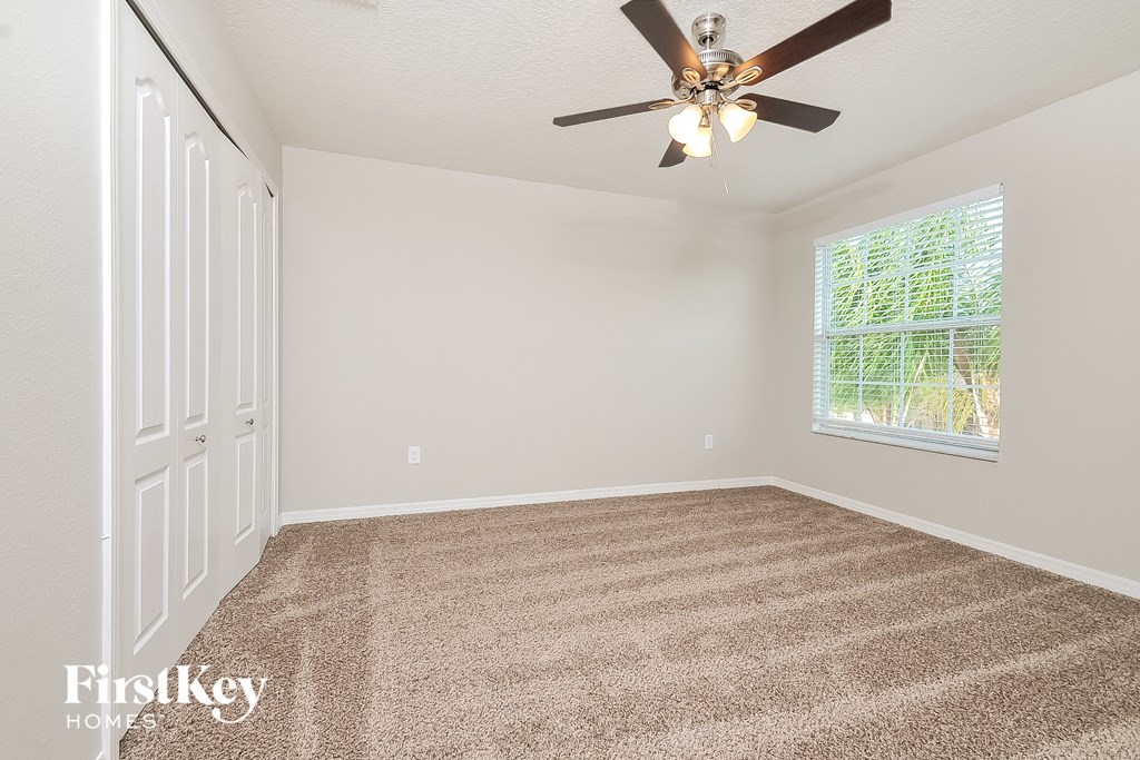 the living room of an empty house with a ceiling fan