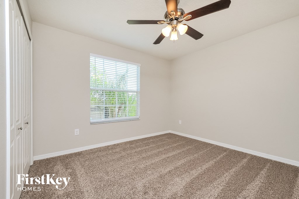 the living room of an empty house with a ceiling fan