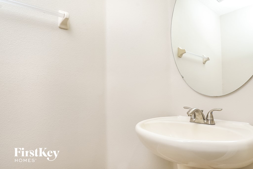 a white bathroom with a sink and a mirror
