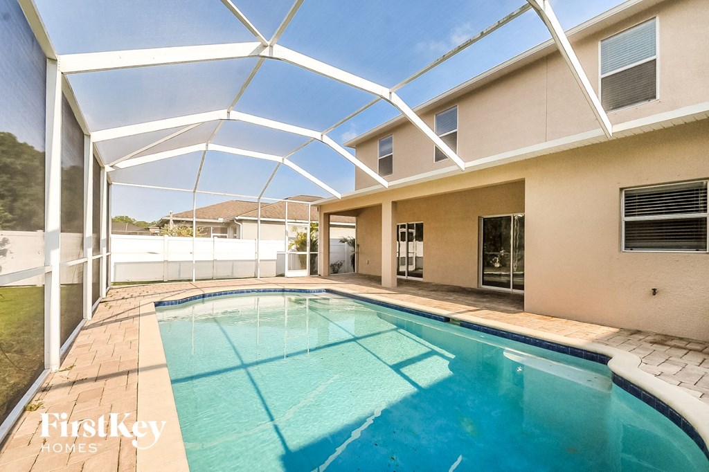 the pool is under an open patio roof with a pool