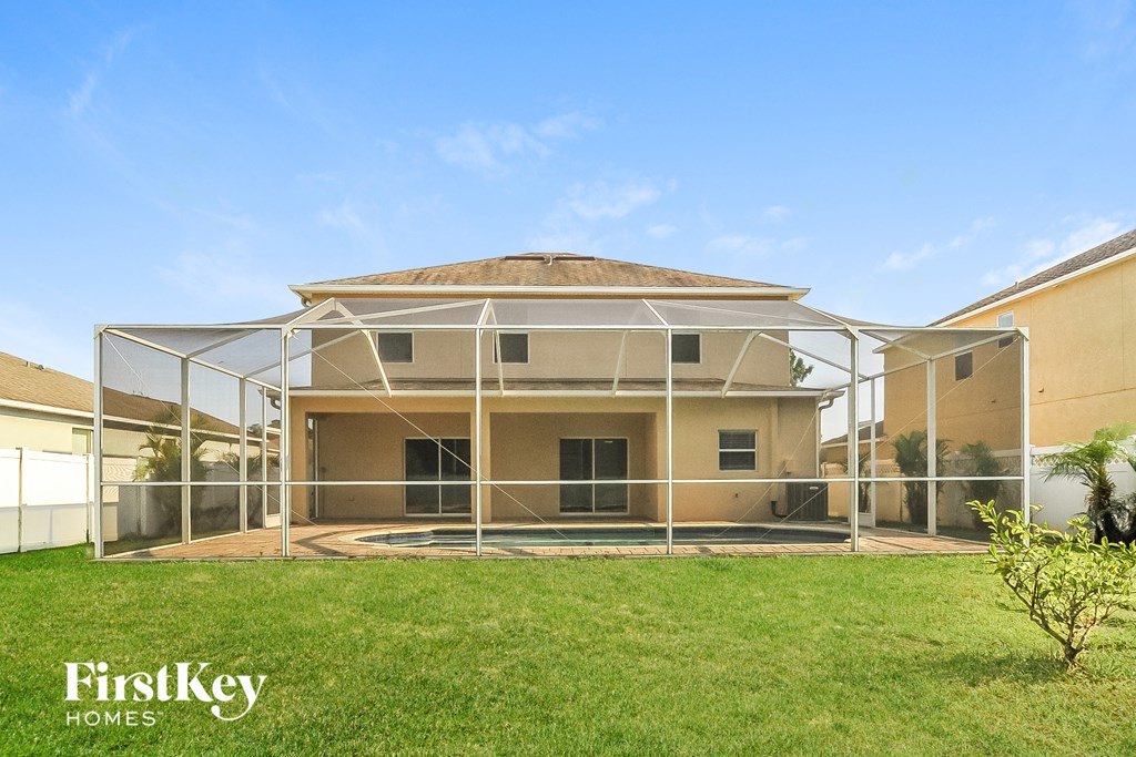 a house with a screened in porch and a grass yard