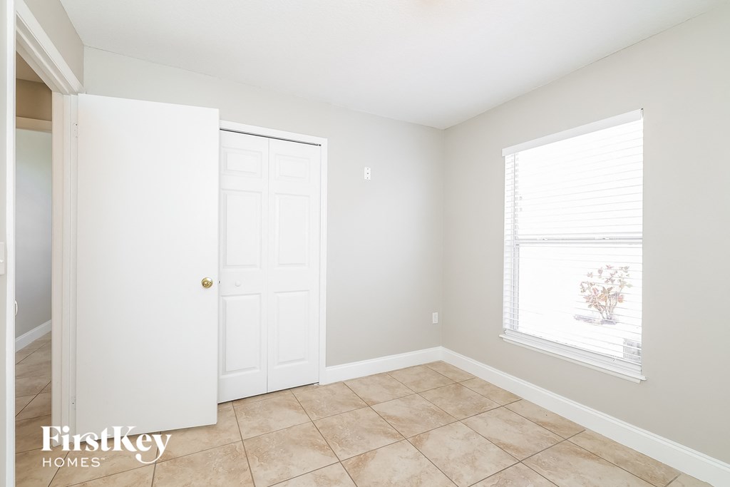 a bedroom with a door and a window and a tiled floor