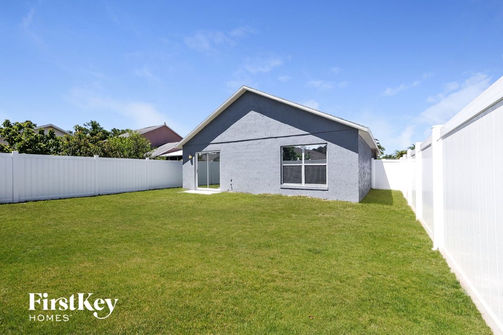 a small with a grass yard and a white fence