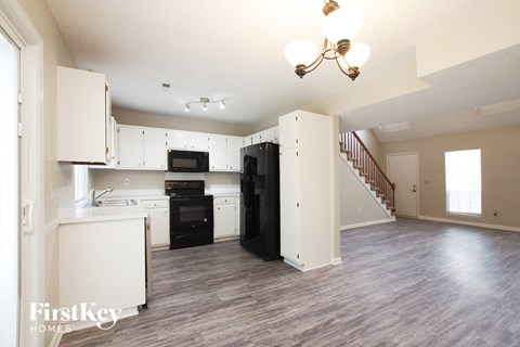 A kitchen with a stove top oven and a refrigerator.
