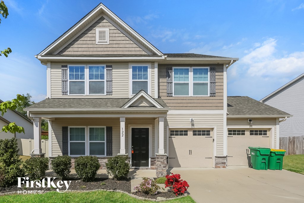 A two-story house with a garage and a driveway.