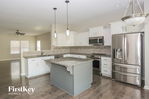 A modern kitchen with a stainless steel refrigerator and a center island.